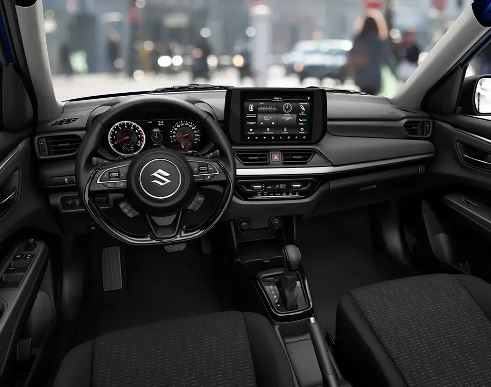 Interior moderno del Suzuki New Swift Smart Híbrido, destacando el volante multifunción y la pantalla táctil central.